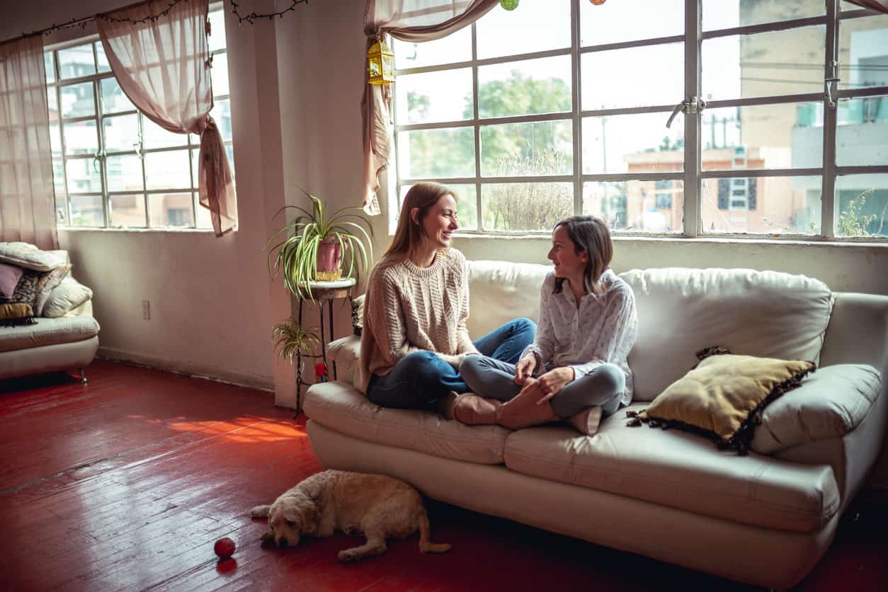 Mom having a thoughtful talk with daughter on sofa