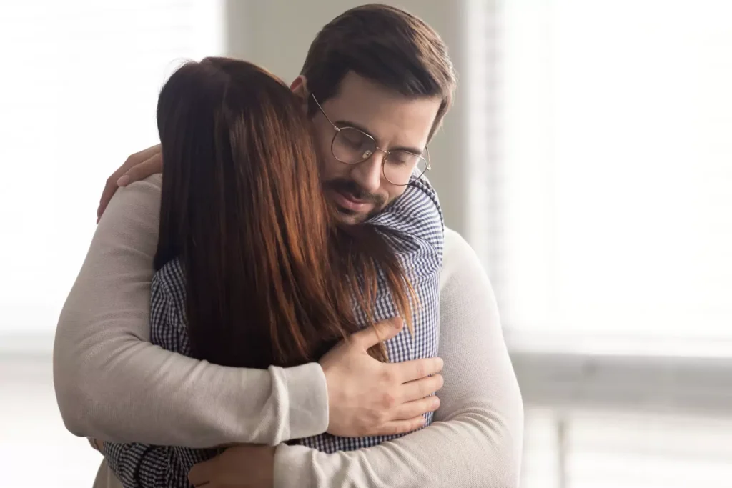 Man and woman embracing in a hug of forgiveness.