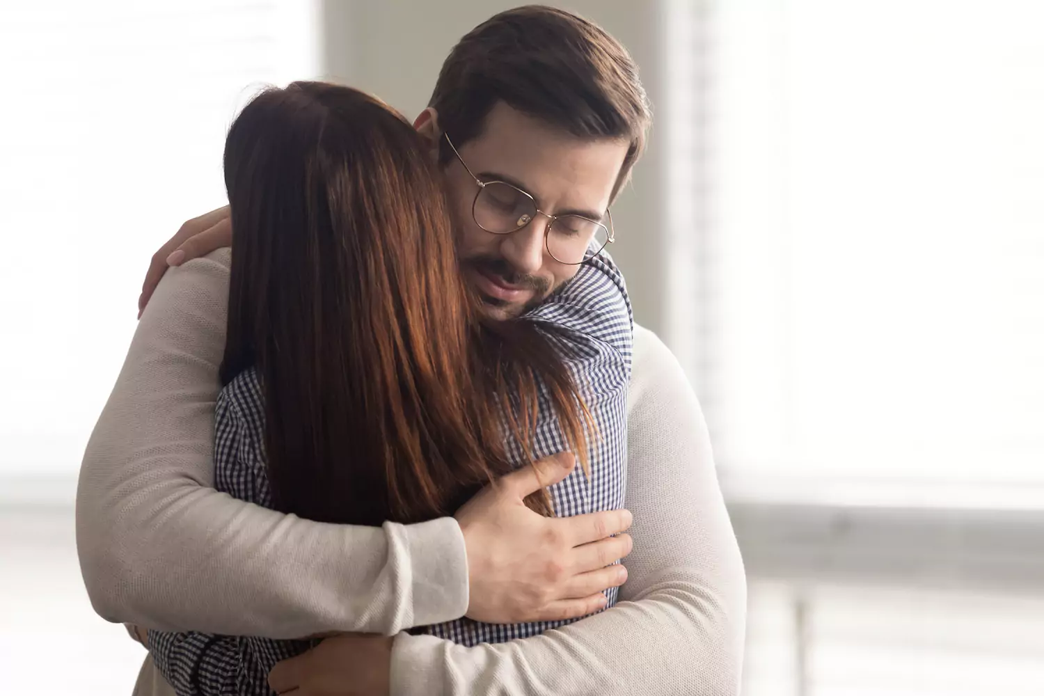 Man and woman embracing in a hug of forgiveness.