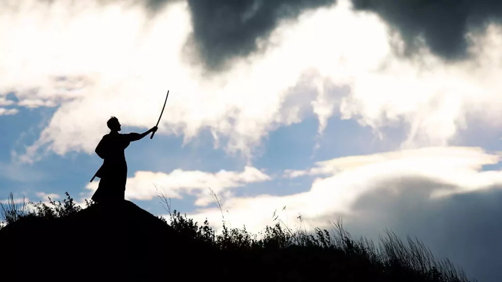 Silhouette of a man holding a sword up at the sky, as his symbolic weapon against depression.