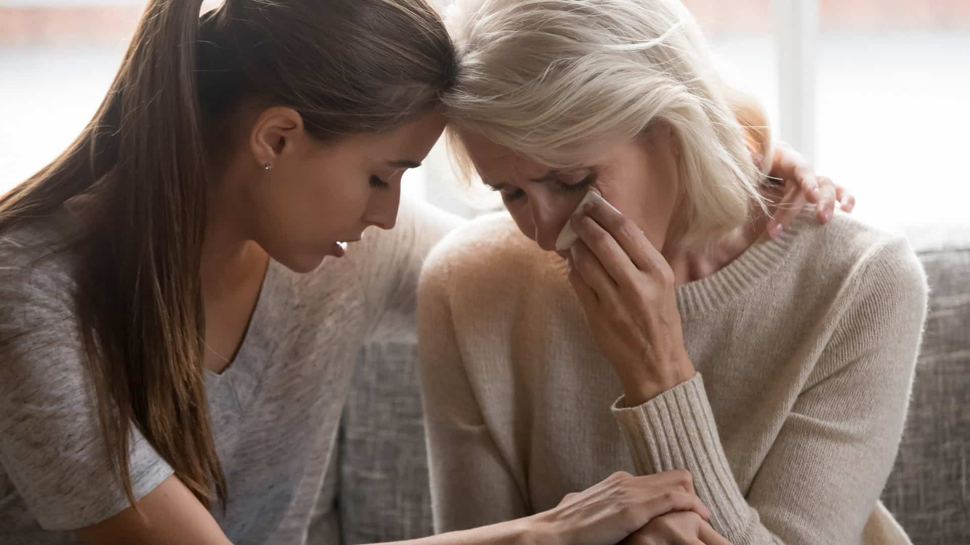 Young woman consoling her crying mother