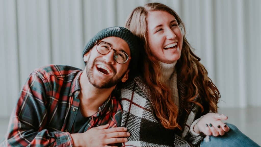 smiling woman and man sitting on floor