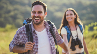 Young man and woman running together outside on an adventure