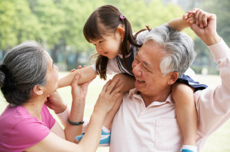 Asian grandparents with their young granddaughter