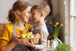 Mother and son lovingly touching foreheads with a basket of dyed Easter eggs