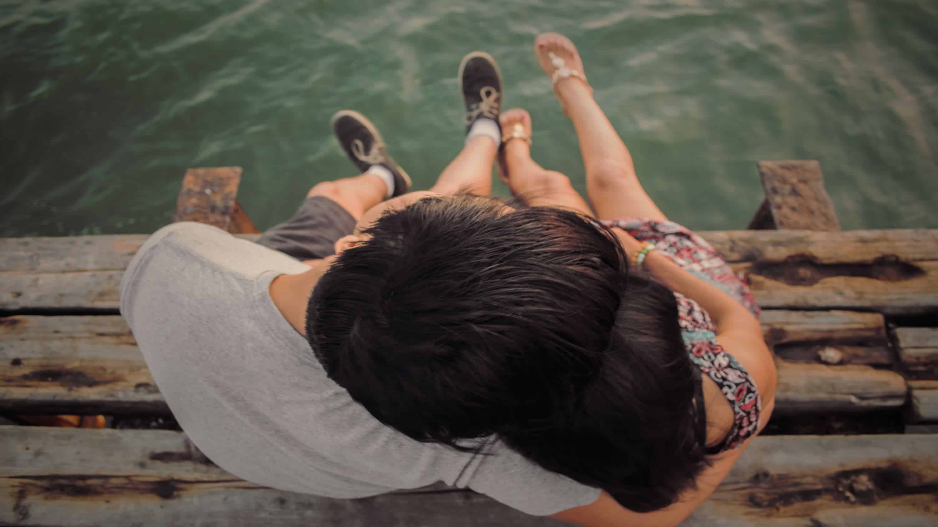 man and women hugging each other on wooden dock