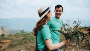 A man hands a bouquet of flowers to his wife.