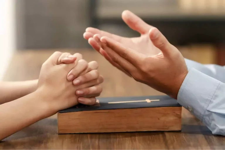 A close up of woman's and man's hands over bible as they try to decide how to choose a church when they don't like the same church.