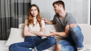 man trying to talk to bored and irritated looking woman