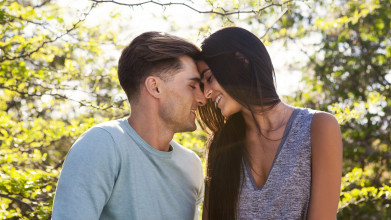 Couple smiling head to head with trees in background