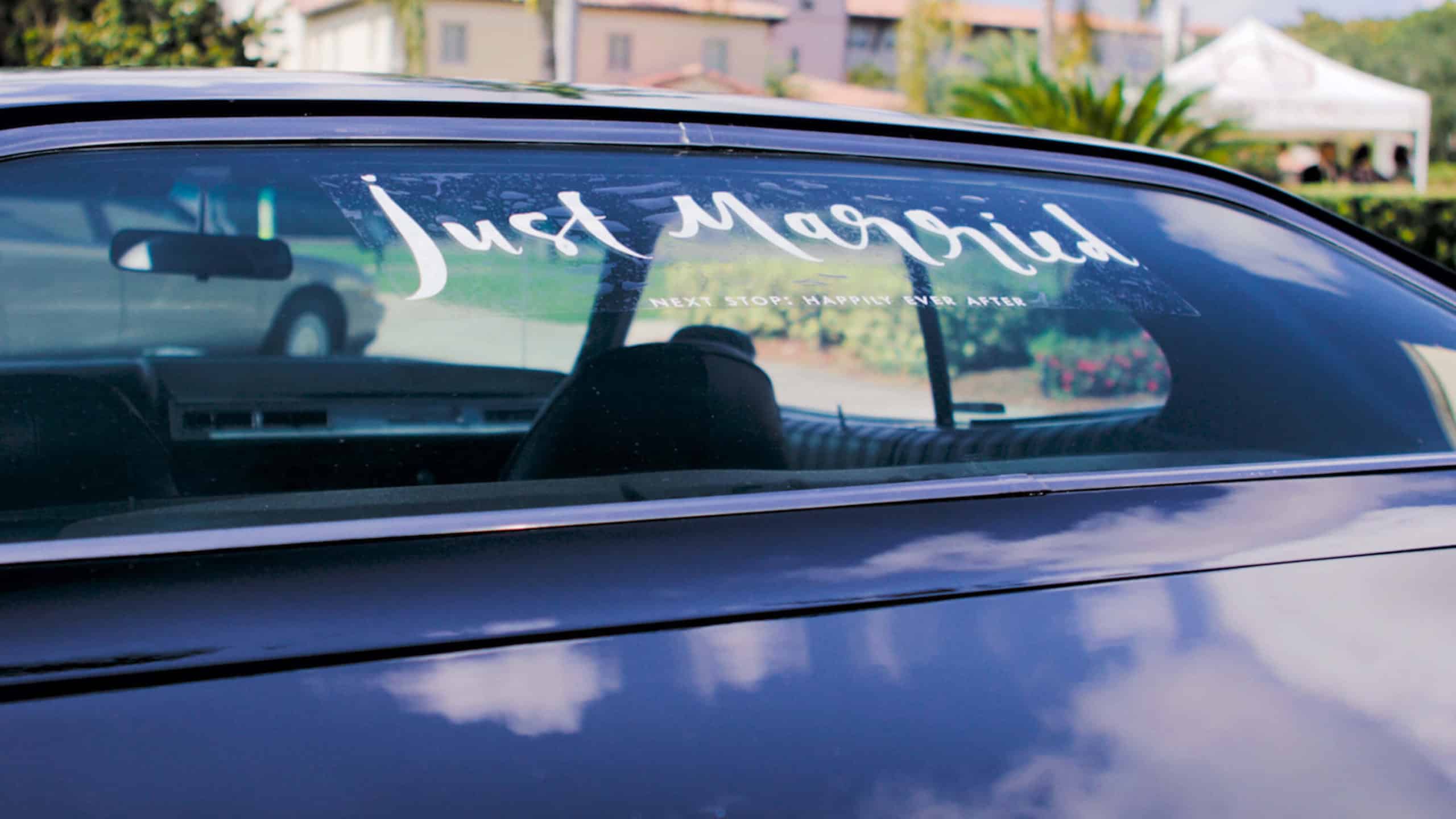 The back window of a car reads Just Married