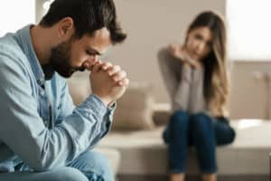 Man praying with concerned woman