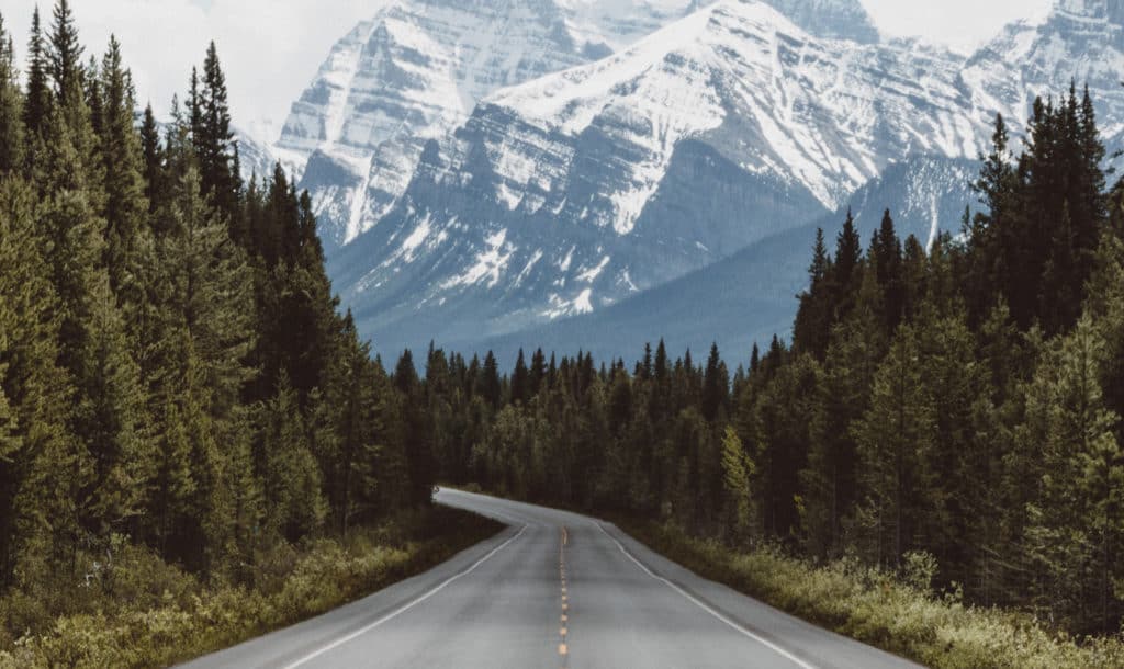 A picture of an open road at the base of the Maroon Bells mountain range.