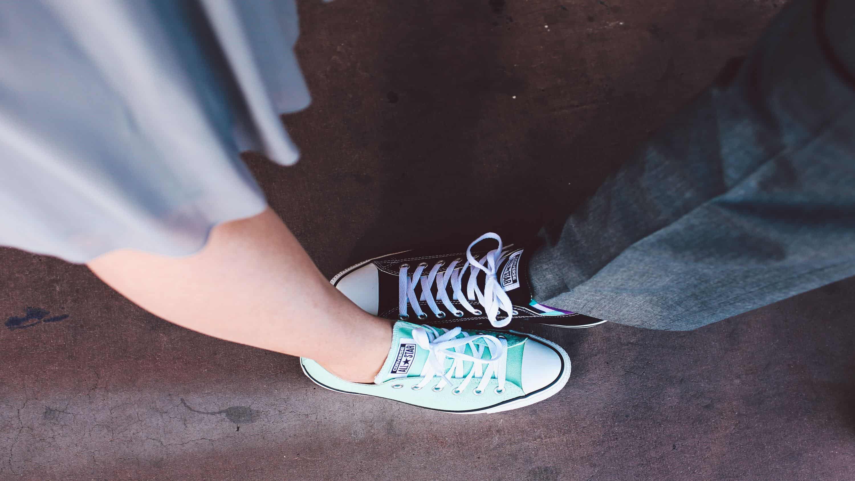 couple with feet side by side in green and black sneakers