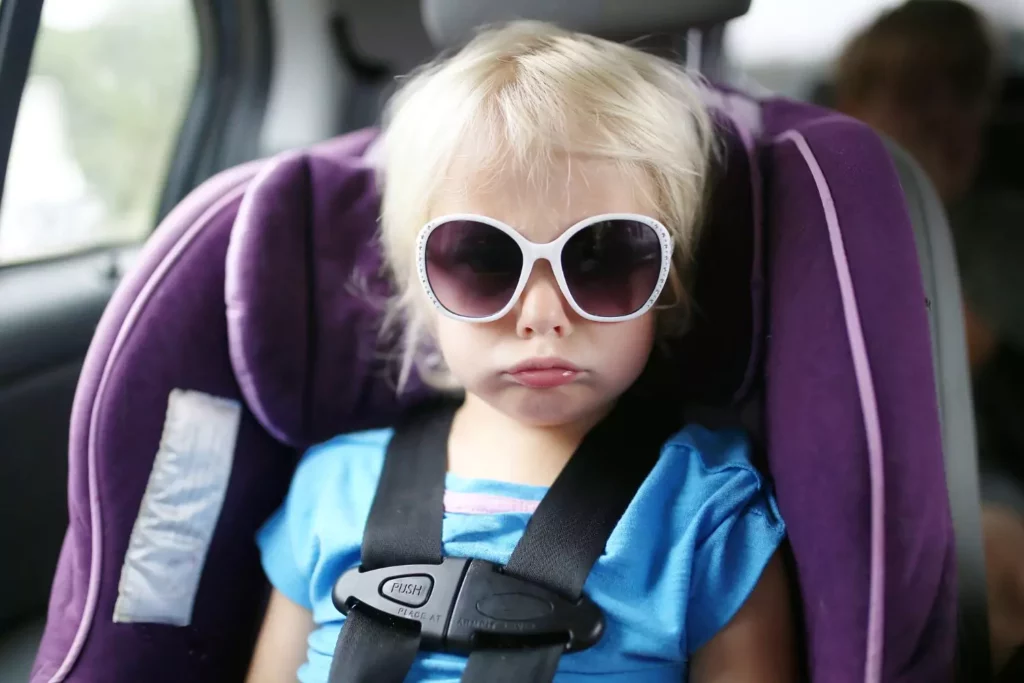 This little girl sitting in her car seat pouting is experiencing reality discipline