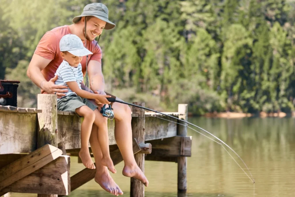 Father and son fishing off a pier.