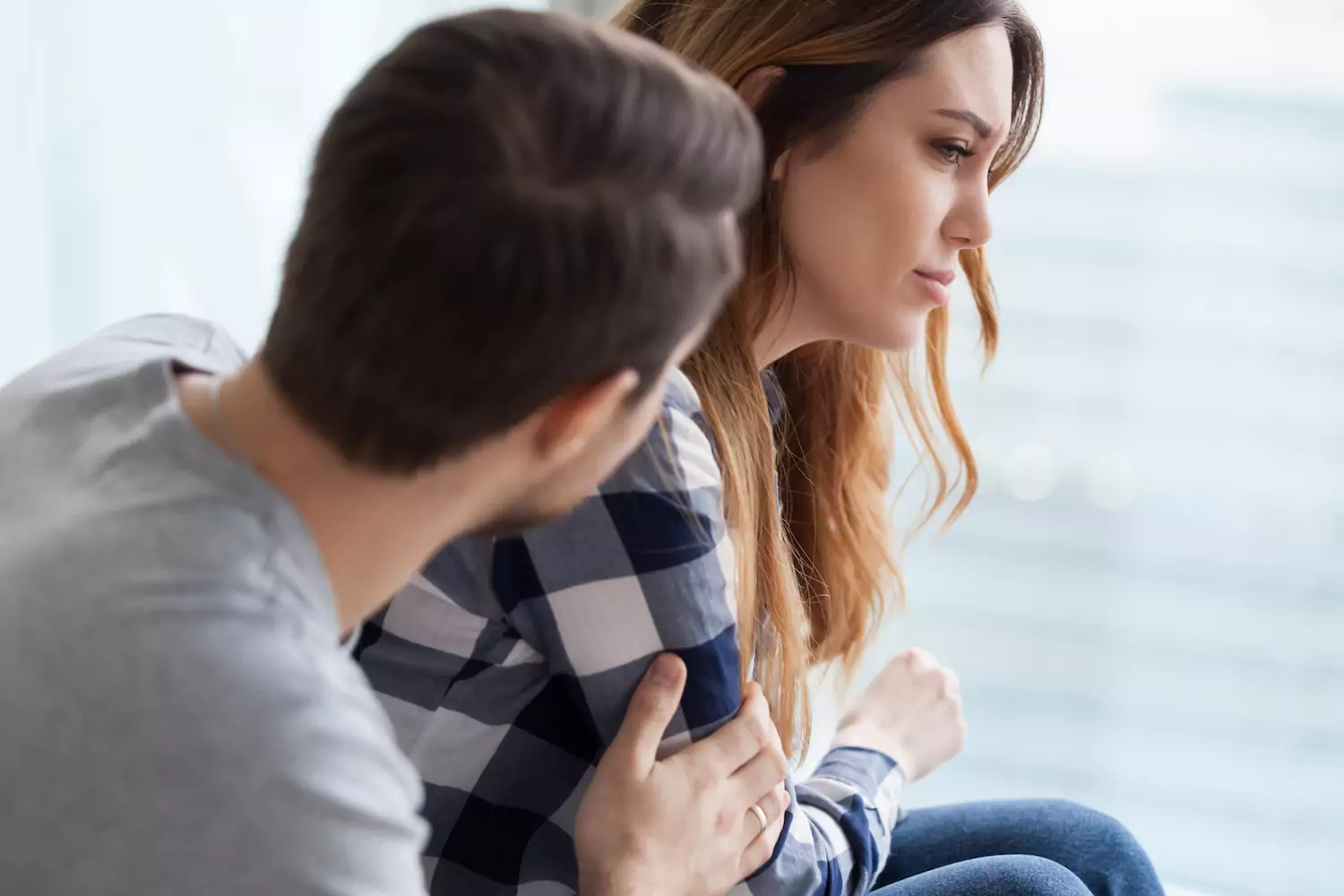 A man seeks forgiveness and restoration of his relationship with his wife, as they sit next to each other. The man comforts his wife as she looks sad and weeps.