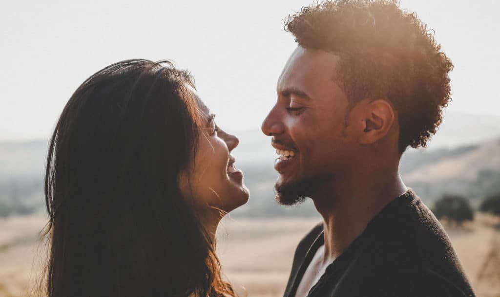 A man and a woman smile at each other lovingly.