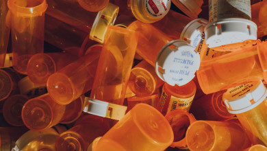 Close up of a pile of empty prescription pill bottles