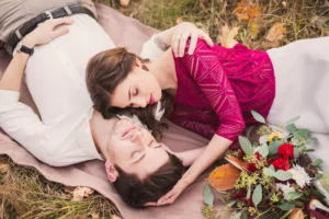 A loving couple lie on a blanket in the grass, embracing each other. Keep the marriage bed pure by resolving conflict in a loving way.