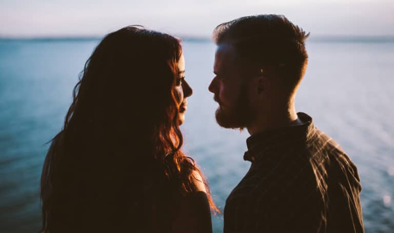 A man and a woman lean into one another.