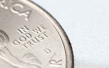 Close up of a quarter, with focus being on the phrase 'In God We Trust'