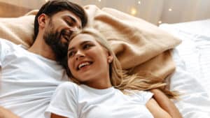 couple cuddle laugh smile in bed