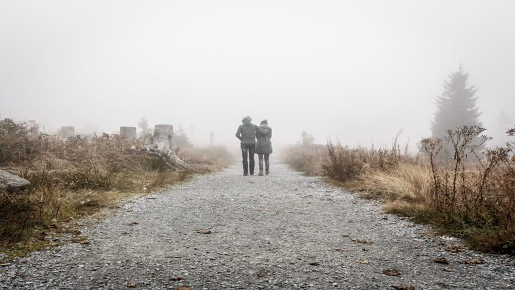 two persons walking on gray road