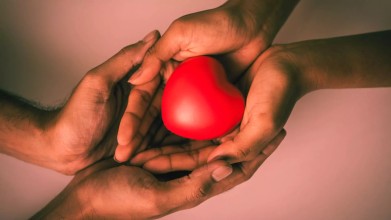 Symbolizing spiritual intimacy, a woman holds a heart and a man cup her hands in his