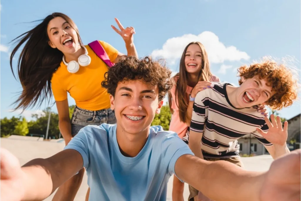 Two teen girls and two teen boys smiling at the camera