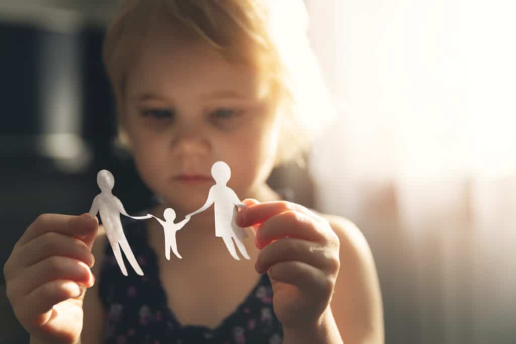 little girl with paper family in hands.