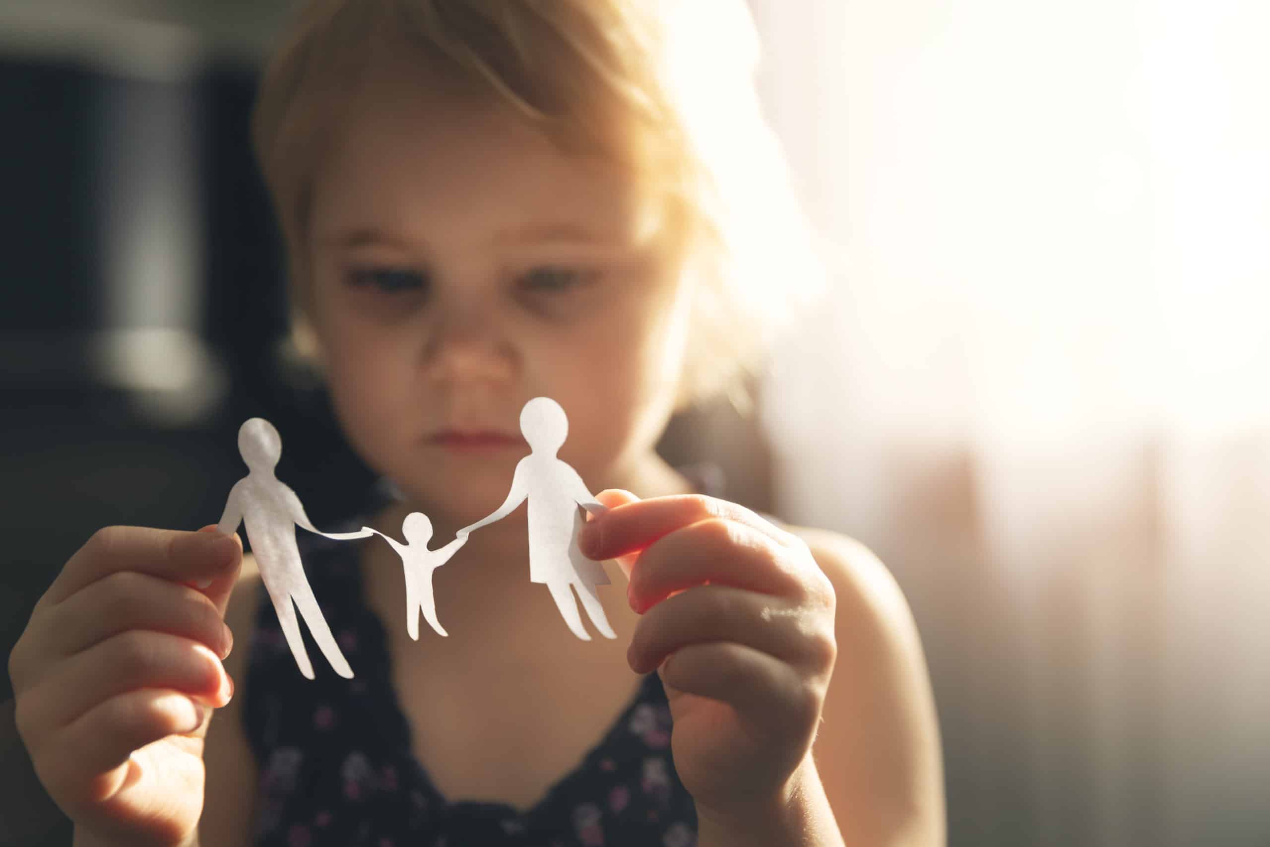 little girl with paper family in hands.