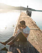 Dad holds toddler on boat dock