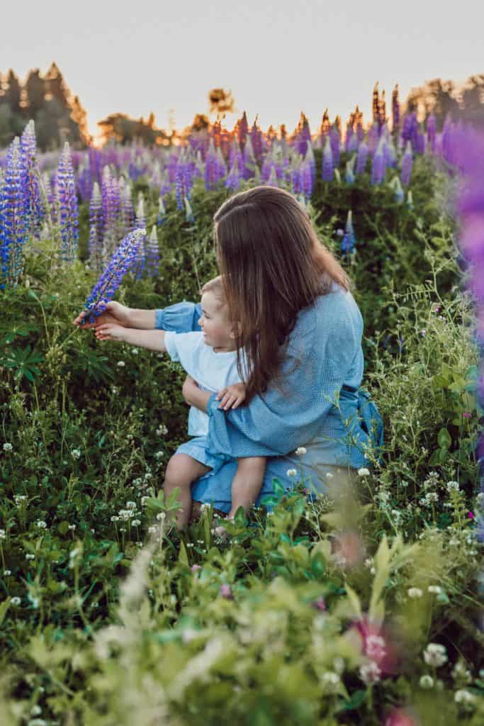 Mom holding young son in field of purple flowers