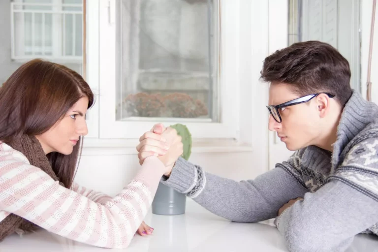 A photo of a couple arm wrestling. Avoid too much competition in marriage. Your spouse is your teammate not your enemy.