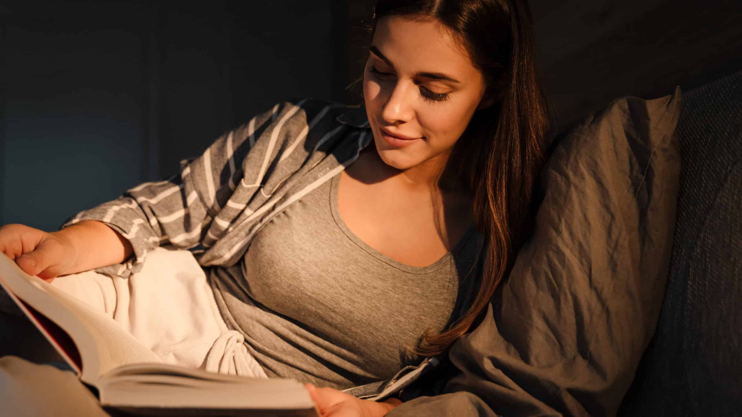 woman reading at night in bed