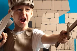 Boy in play armor and holding out a toy sword