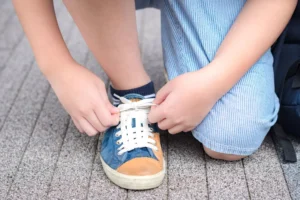 growing tween tying his shoe