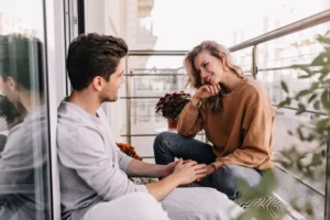 A couple sites on a balcony discussing their issues. Humility in marriage conflict is key.