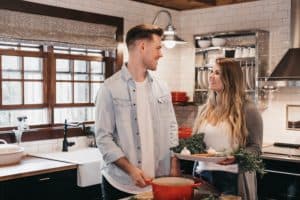 Husband and wife working together in kitchen