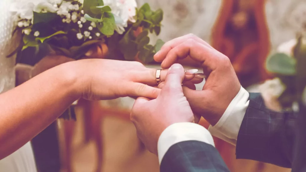 photo of man putting a wedding band on his bride's hand at the altar. They have a plan for both their wedding and their marriage.
