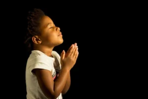 Young child with hands folded in prayer