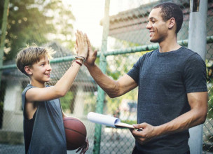 Coach giving a high five to one of the boys on his basketball team