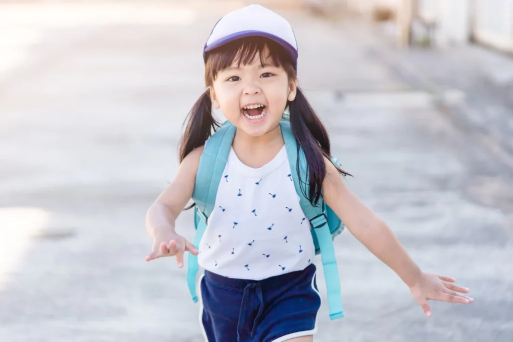 back to school tips little girl with a big smile and backpack happy to go back to school.