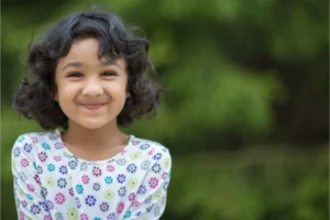 Young girl outdoors looking at camera and smiling