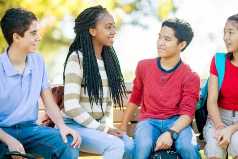 Friends talking as they sit on a bench