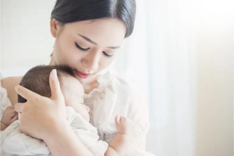 Mom holding a new baby close in her arms