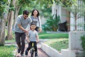 parenting with intentionality: happy kid with his father learning how to ride a bicycle using push or balance bike