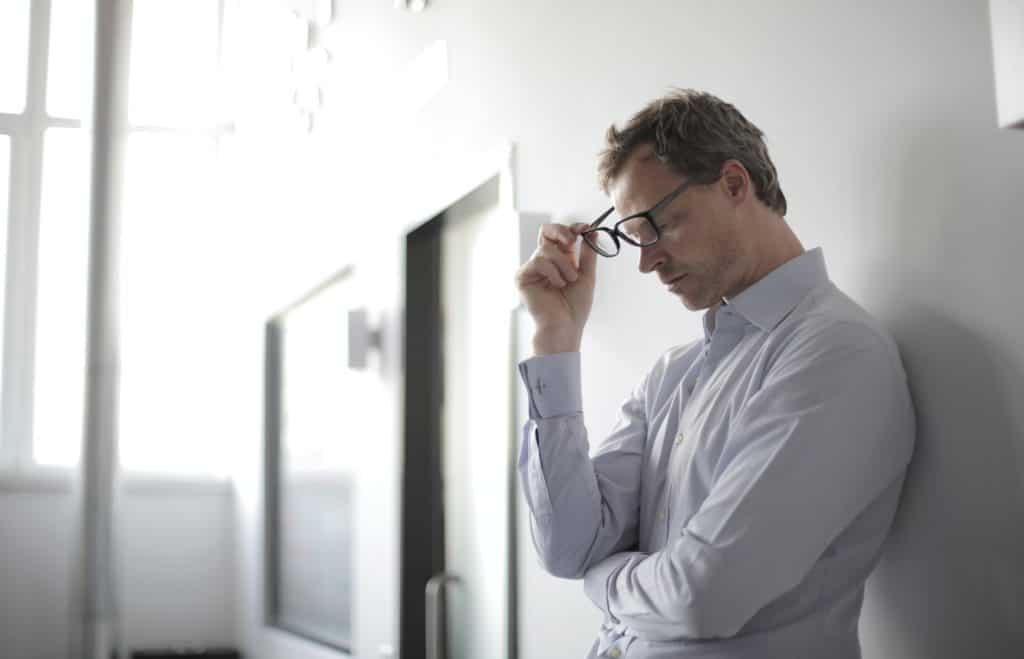 frustrated man leaning against wall