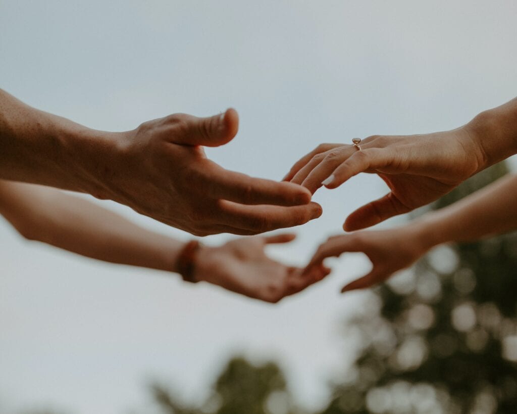 Husband and wife reaching out hands to one another